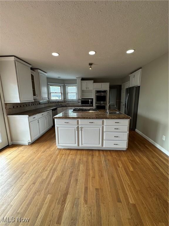 5330 Willow Ln, Sheffield Lake, OH 44054 - kitchen with stainless steel appliances, recessed lighting, light wood-style flooring, a textured ceiling, and white cabinetry