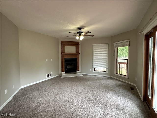 5330 Willow Ln, Sheffield Lake, OH 44054 - unfurnished living room with dark carpet, a ceiling fan, and a fireplace with raised hearth