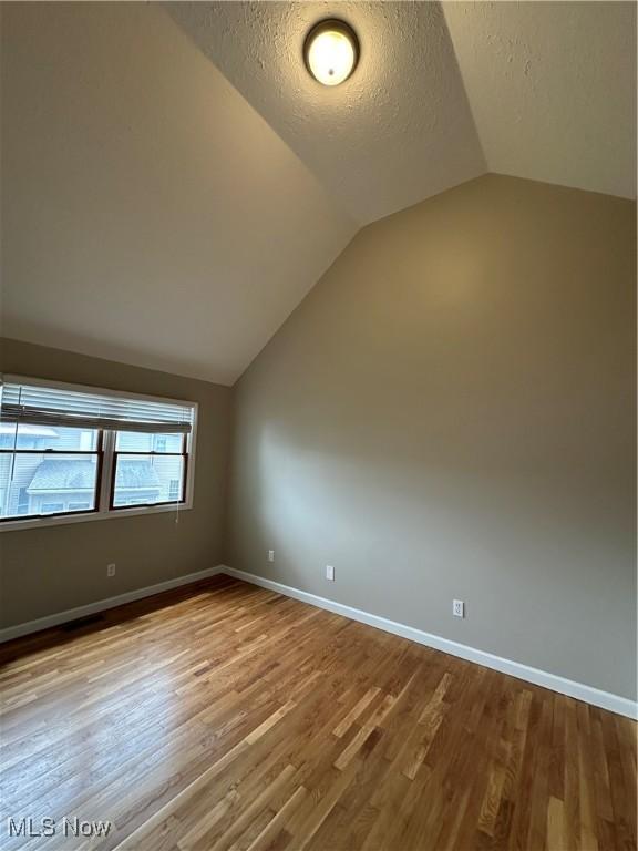 5330 Willow Ln, Sheffield Lake, OH 44054 - bonus room with lofted ceiling, wood finished floors, and a textured ceiling