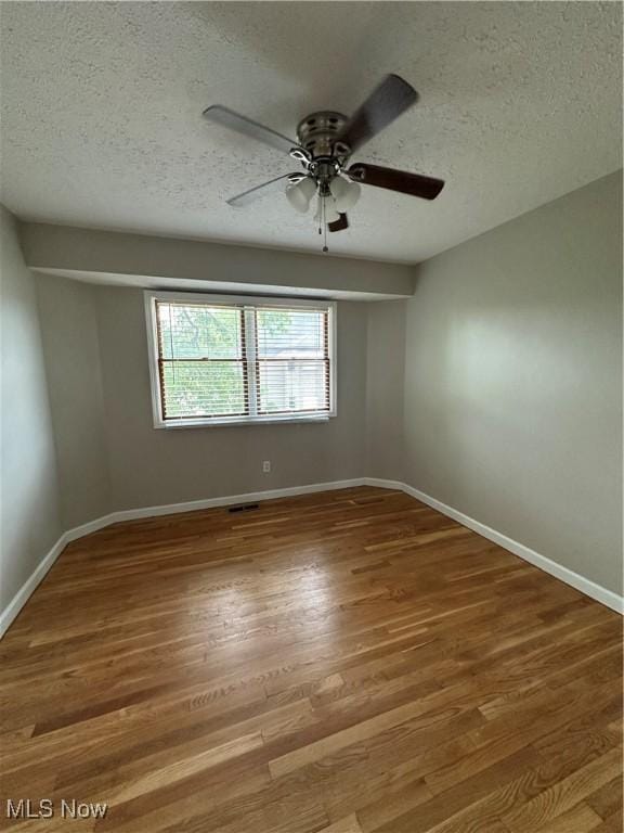5330 Willow Ln, Sheffield Lake, OH 44054 - spare room featuring a textured ceiling, ceiling fan, and wood finished floors