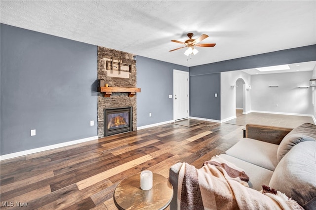 8743 Usher Rd, Olmsted Twp, OH 44138 - living room with arched walkways, ceiling fan, wood finished floors, and a fireplace