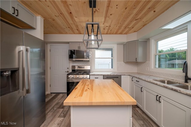595 Elm St, Struthers, OH 44471 - kitchen featuring stainless steel appliances, wooden counters, wooden ceiling, wood finished floors, and decorative backsplash