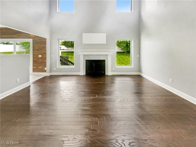 3217 Deborah Ct, Uniontown, OH 44685 - unfurnished living room with plenty of natural light, a towering ceiling, dark wood-type flooring, and a fireplace