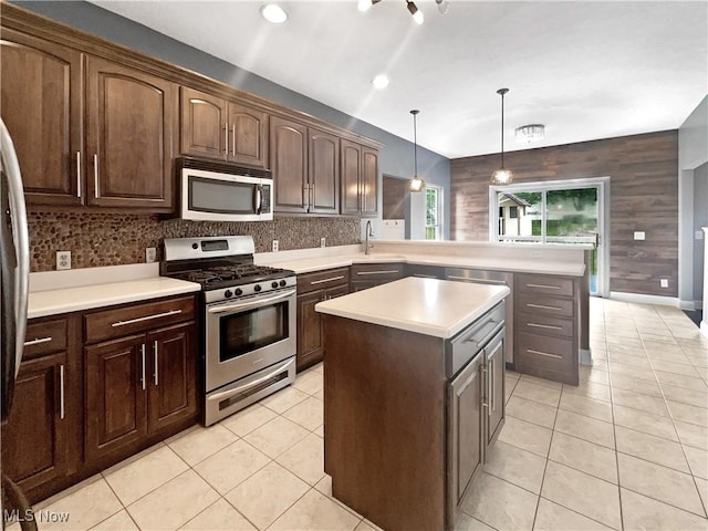 3217 Deborah Ct, Uniontown, OH 44685 - kitchen featuring appliances with stainless steel finishes, a peninsula, a center island, light countertops, and light tile patterned floors