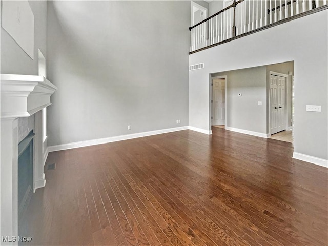3217 Deborah Ct, Uniontown, OH 44685 - unfurnished living room with a towering ceiling, dark wood finished floors, and a fireplace