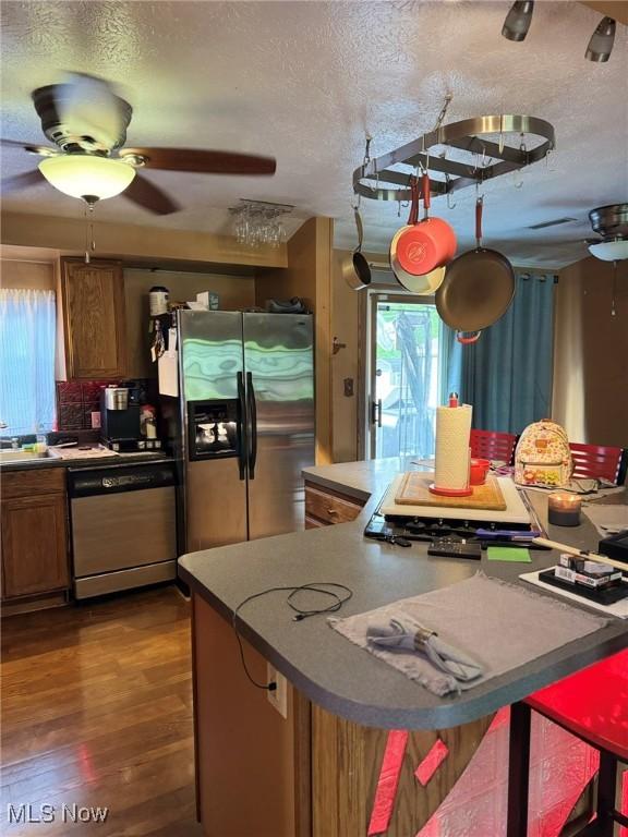 20684 Albion Rd, Strongsville, OH 44149 - kitchen with stainless steel fridge with ice dispenser, dishwashing machine, ceiling fan, a textured ceiling, and brown cabinetry