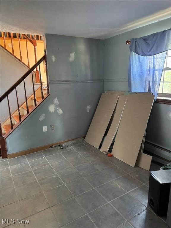 20684 Albion Rd, Strongsville, OH 44149 - tiled empty room featuring a baseboard heating unit and stairway
