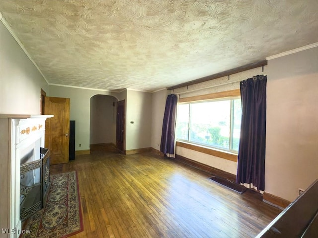 2323 Scholl Rd, University Heights, OH 44118 - unfurnished living room with arched walkways, hardwood / wood-style floors, a textured ceiling, crown molding, and a fireplace