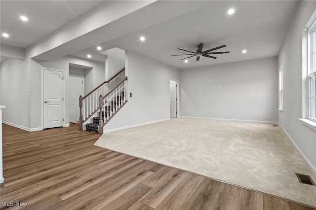 1809 Muirfield Ln, Painesville, OH 44077 - unfurnished living room with recessed lighting, light wood-type flooring, a ceiling fan, stairs, and light carpet