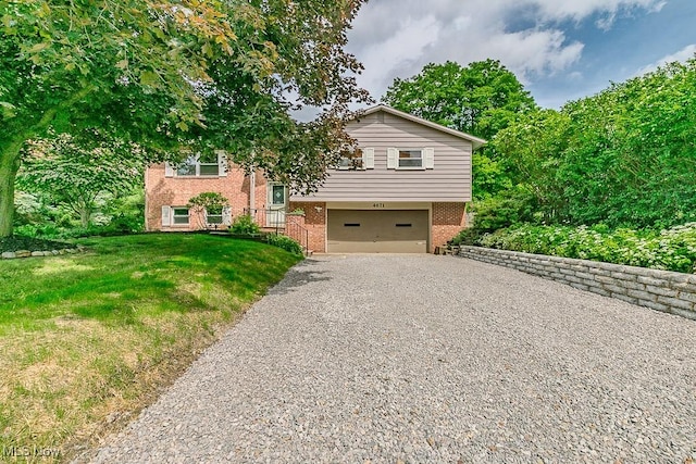 4671 Milford Dr, Perry, OH 44081 - raised ranch featuring brick siding, gravel driveway, an attached garage, and a front lawn