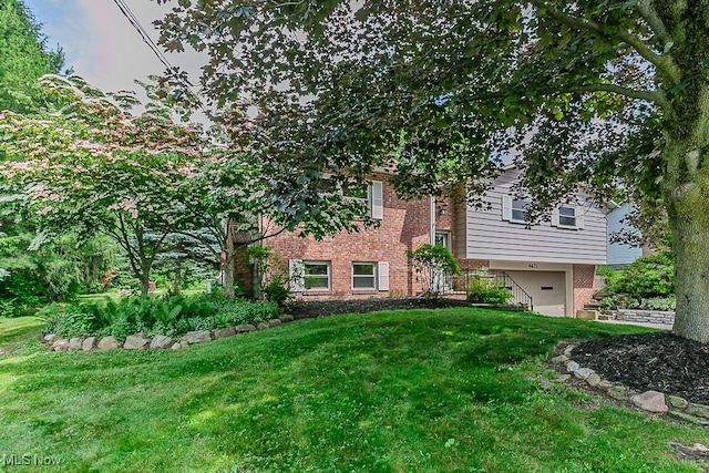4671 Milford Dr, Perry, OH 44081 - view of front facade with brick siding, a garage, and a front lawn