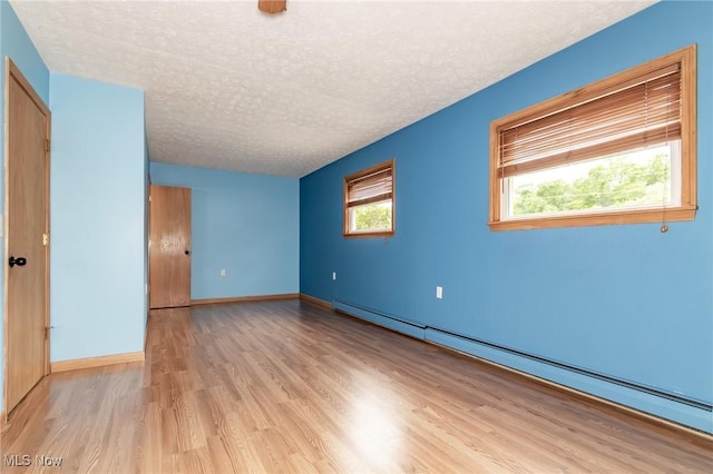 4671 Milford Dr, Perry, OH 44081 - unfurnished room with a baseboard heating unit, a textured ceiling, and light wood-type flooring