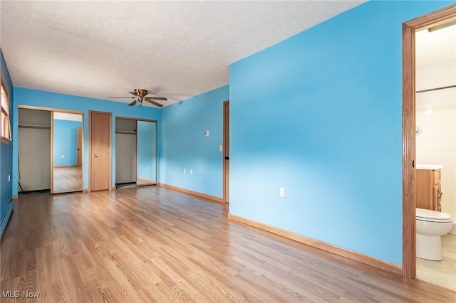4671 Milford Dr, Perry, OH 44081 - unfurnished bedroom featuring wood finished floors, two closets, connected bathroom, a textured ceiling, and a ceiling fan