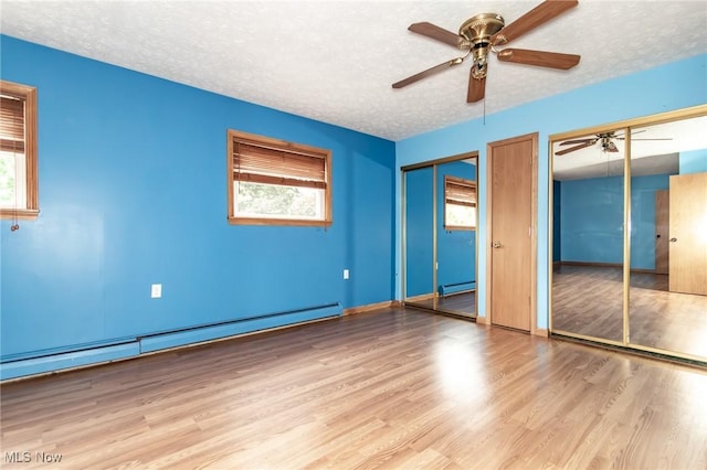 4671 Milford Dr, Perry, OH 44081 - unfurnished bedroom with a baseboard radiator, two closets, wood finished floors, a textured ceiling, and a baseboard heating unit