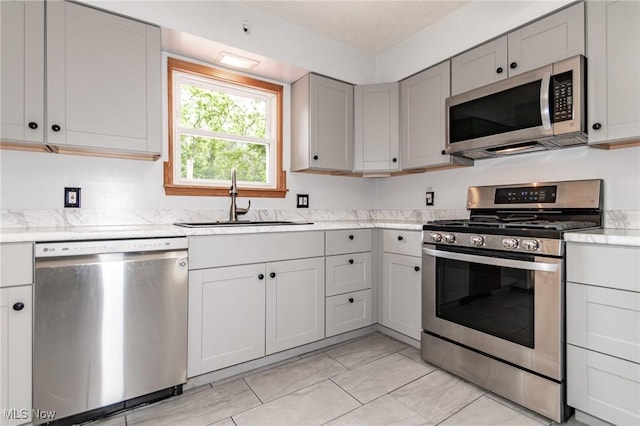 4671 Milford Dr, Perry, OH 44081 - kitchen featuring stainless steel appliances, gray cabinetry, light countertops, and light marble finish floors