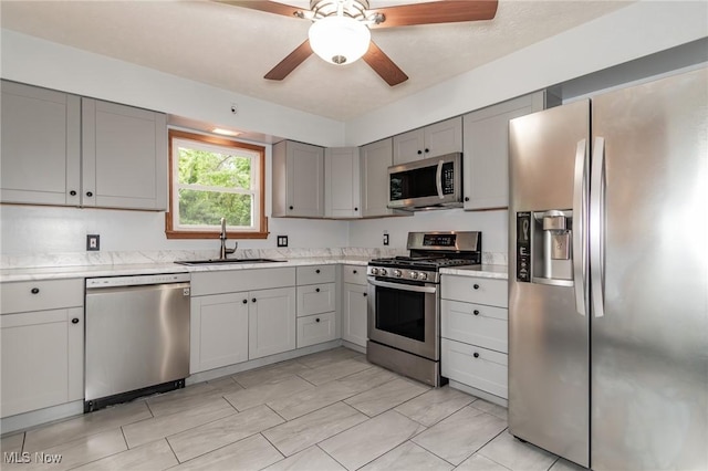 4671 Milford Dr, Perry, OH 44081 - kitchen with stainless steel appliances, gray cabinetry, a ceiling fan, and light stone countertops