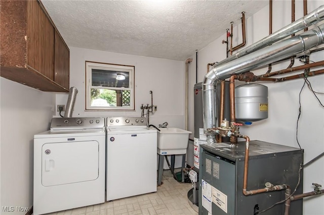 4671 Milford Dr, Perry, OH 44081 - laundry room featuring independent washer and dryer, cabinet space, water heater, a heating unit, and a textured ceiling