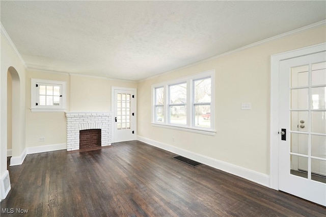 2231 16th St, Cuyahoga Falls, OH 44223 - unfurnished living room with ornamental molding, dark wood-type flooring, arched walkways, a brick fireplace, and a textured ceiling