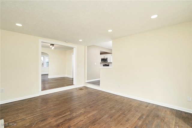 2231 16th St, Cuyahoga Falls, OH 44223 - spare room with dark wood-type flooring, recessed lighting, and arched walkways
