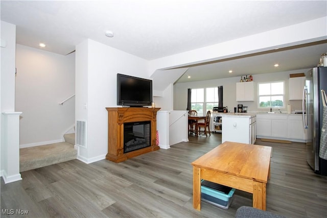 393 Slate Rdg, Barberton, OH 44203 - living area featuring light wood-style floors, a glass covered fireplace, stairway, and recessed lighting