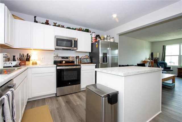 393 Slate Rdg, Barberton, OH 44203 - kitchen with stainless steel appliances, wood finished floors, light countertops, a center island, and white cabinets