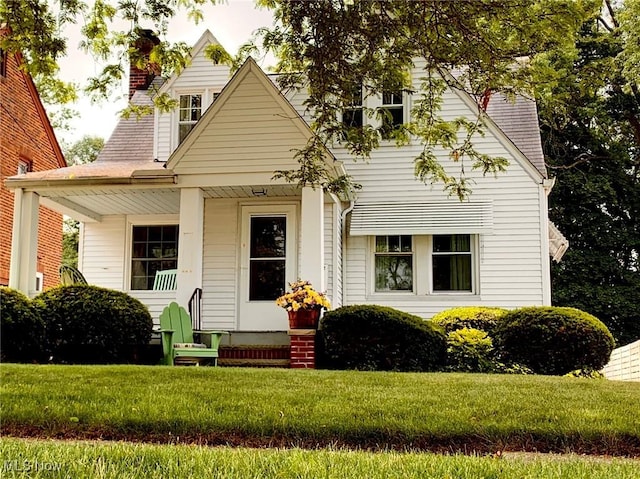 21437 Hillsdale Ave, Fairview Park, OH 44126 - view of front facade featuring a chimney, a front lawn, and covered porch
