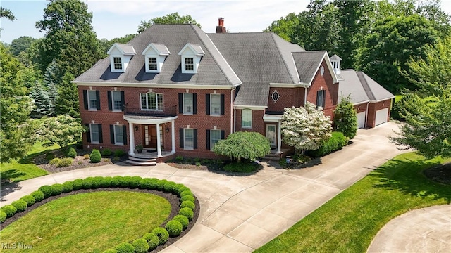 23225 Wingedfoot Dr, Westlake, OH 44145 - georgian-style home with curved driveway, brick siding, a chimney, and a front lawn