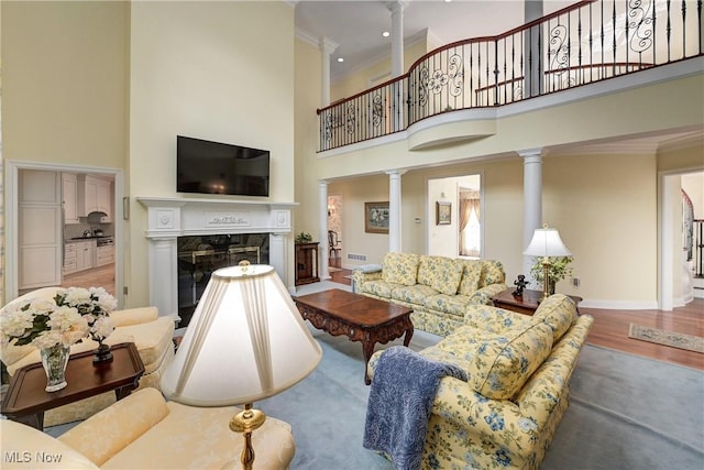 23225 Wingedfoot Dr, Westlake, OH 44145 - living area featuring a high ceiling, decorative columns, ornamental molding, a premium fireplace, and wood finished floors