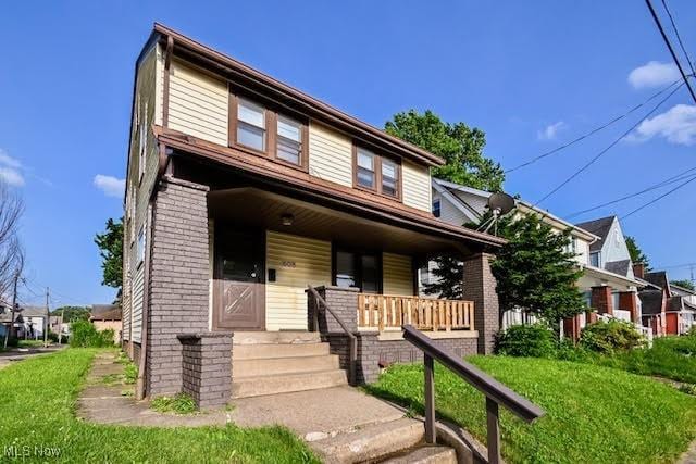 608 Columbus Ave NW, Canton, OH 44708 - view of front of house featuring covered porch, brick siding, and a front yard