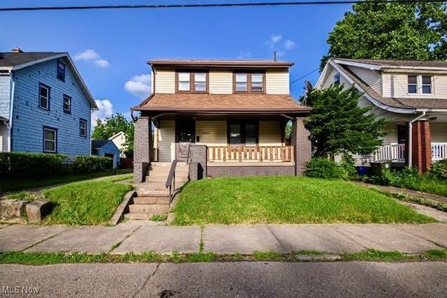 608 Columbus Ave NW, Canton, OH 44708 - view of front of home featuring a porch, brick siding, and a front yard