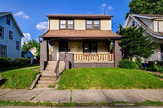 608 Columbus Ave NW, Canton, OH 44708 - view of front of home with a porch, a front lawn, and brick siding