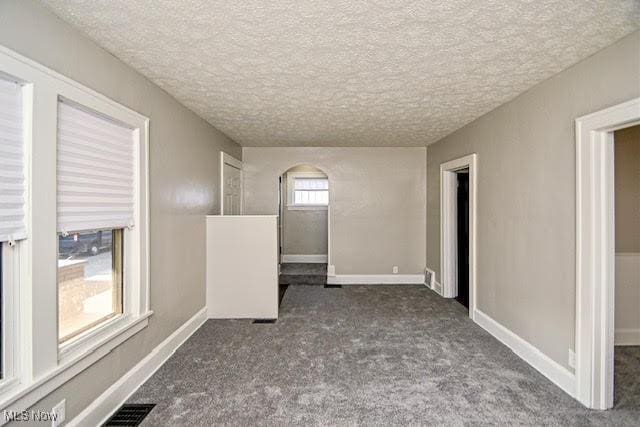 608 Columbus Ave NW, Canton, OH 44708 - spare room featuring carpet, a textured ceiling, and arched walkways