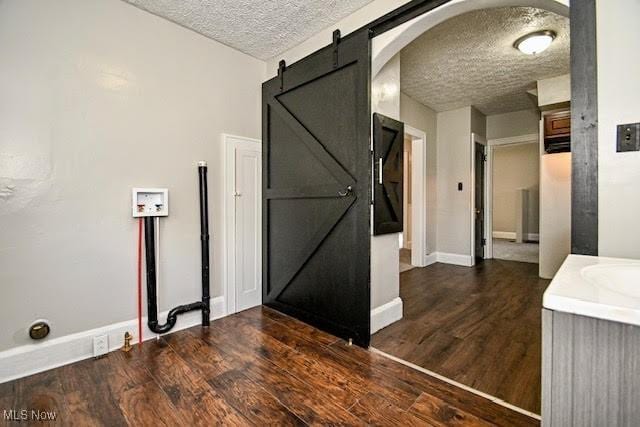 608 Columbus Ave NW, Canton, OH 44708 - corridor featuring a barn door, a textured ceiling, wood finished floors, and arched walkways