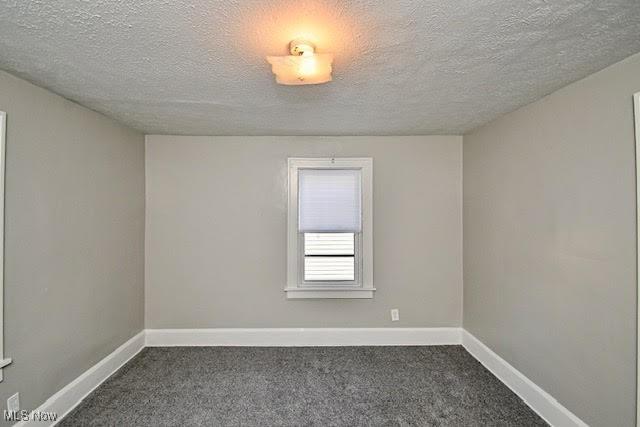 608 Columbus Ave NW, Canton, OH 44708 - unfurnished room featuring dark carpet and a textured ceiling