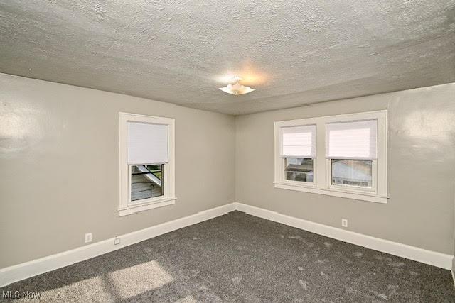 608 Columbus Ave NW, Canton, OH 44708 - empty room featuring dark colored carpet and a textured ceiling