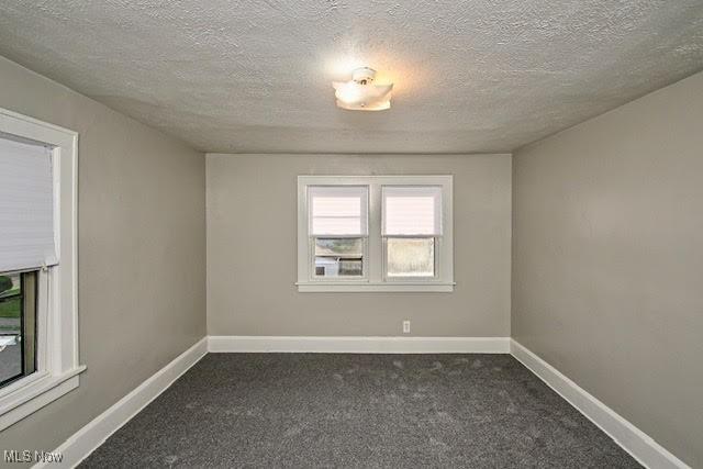 608 Columbus Ave NW, Canton, OH 44708 - unfurnished room with dark colored carpet and a textured ceiling