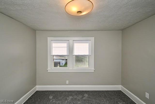 608 Columbus Ave NW, Canton, OH 44708 - spare room with dark carpet and a textured ceiling