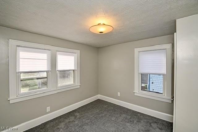 608 Columbus Ave NW, Canton, OH 44708 - unfurnished room with dark carpet and a textured ceiling