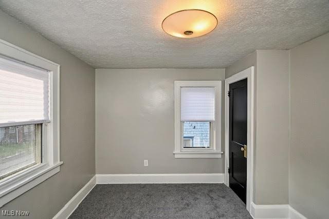 608 Columbus Ave NW, Canton, OH 44708 - empty room with a textured ceiling and dark carpet