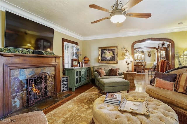 3571 Greenwich Rd, Barberton, OH 44203 - living area featuring wood finished floors, ornamental molding, a fireplace, arched walkways, and a ceiling fan