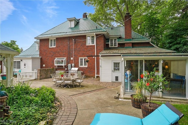 3571 Greenwich Rd, Barberton, OH 44203 - back of house featuring a chimney, brick siding, and a patio