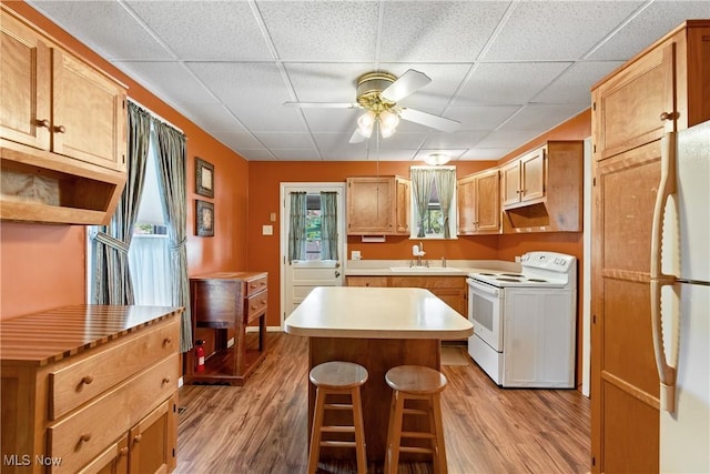 811 E High Ave, New Philadelphia, OH 44663 - kitchen featuring white appliances, a ceiling fan, light wood-type flooring, a center island, and a paneled ceiling