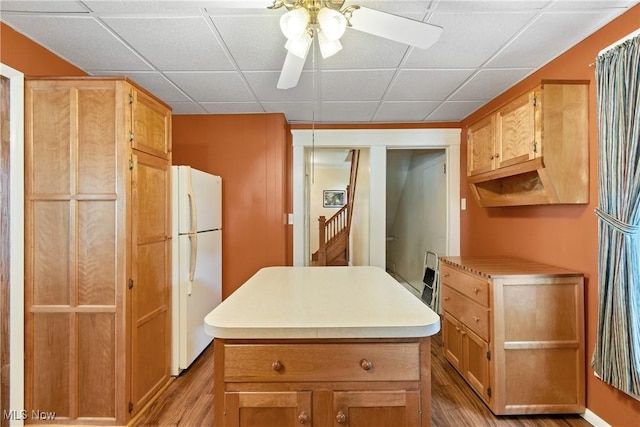 811 E High Ave, New Philadelphia, OH 44663 - kitchen with freestanding refrigerator, light wood-type flooring, a ceiling fan, light countertops, and a center island