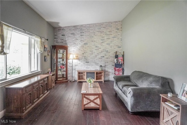1324 Woodrow St NW, North Canton, OH 44720 - living area featuring dark wood finished floors, vaulted ceiling, and brick wall