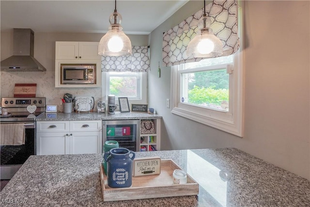 1324 Woodrow St NW, North Canton, OH 44720 - kitchen with wall chimney exhaust hood, electric range, built in microwave, beverage cooler, and white cabinetry