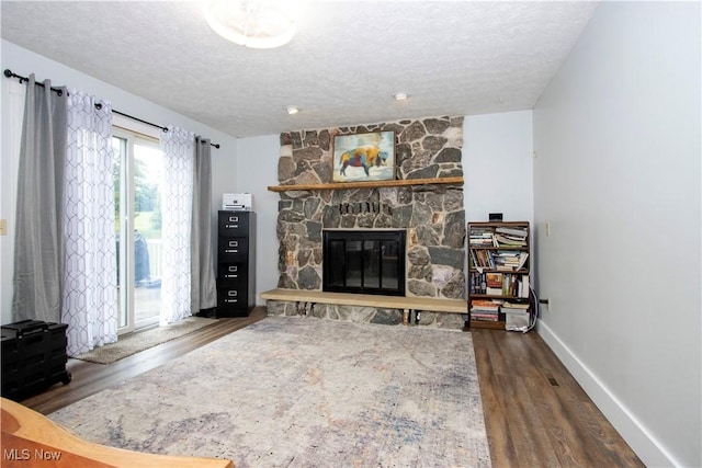 13946 Highview Dr, Dalton, OH 44618 - living area with wood finished floors, a textured ceiling, and a stone fireplace