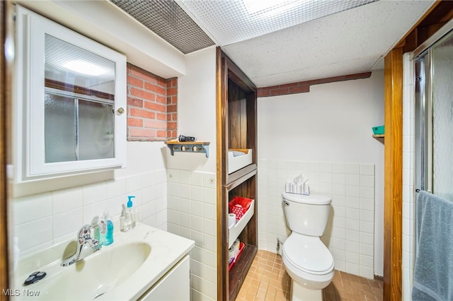 30888 Harrison Rd, Wickliffe, OH 44092 - full bath featuring tile walls, vanity, tile patterned floors, a shower with shower door, and a wainscoted wall