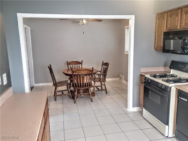 5752 Van Wert Ave, Brook Park, OH 44142 - kitchen featuring black appliances, light countertops, a ceiling fan, light tile patterned floors, and light brown cabinetry