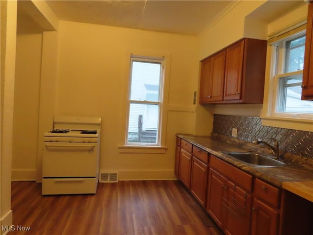 278 Wheeler St, Akron, OH 44304 - kitchen featuring gas range gas stove, dark wood-style floors, tasteful backsplash, dark countertops, and brown cabinets