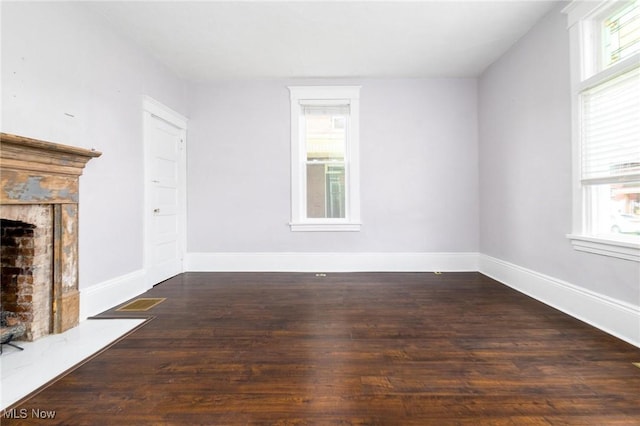 719 N 3rd St, Toronto, OH 43964 - unfurnished living room featuring healthy amount of natural light, wood finished floors, and a fireplace with flush hearth